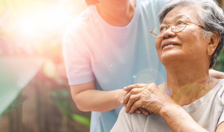 Caregiver assisting an elderly person with daily activities, such as bathing or dressing, while being vigilant against potential elder financial abuse.