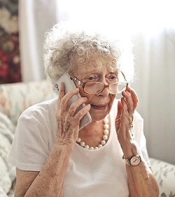 Elderly woman sitting on a call with a worried look on her face